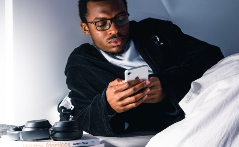 Man in bed looking at phone