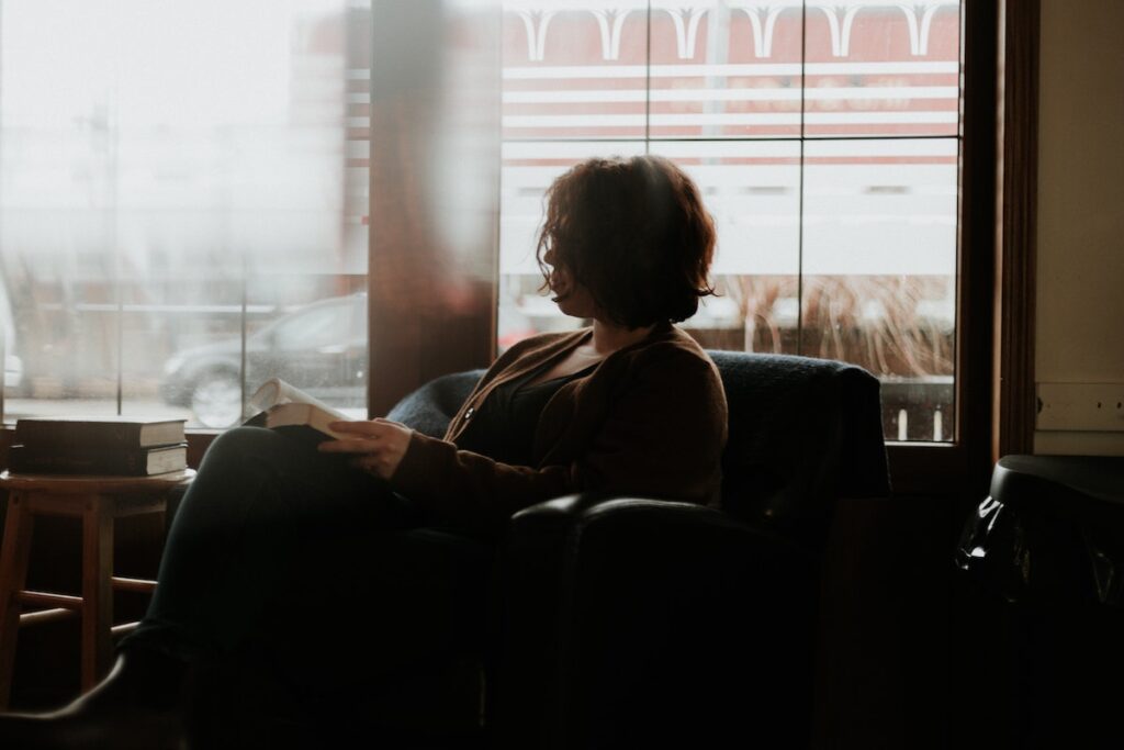 Young woman sat in an armchair looking out of the window