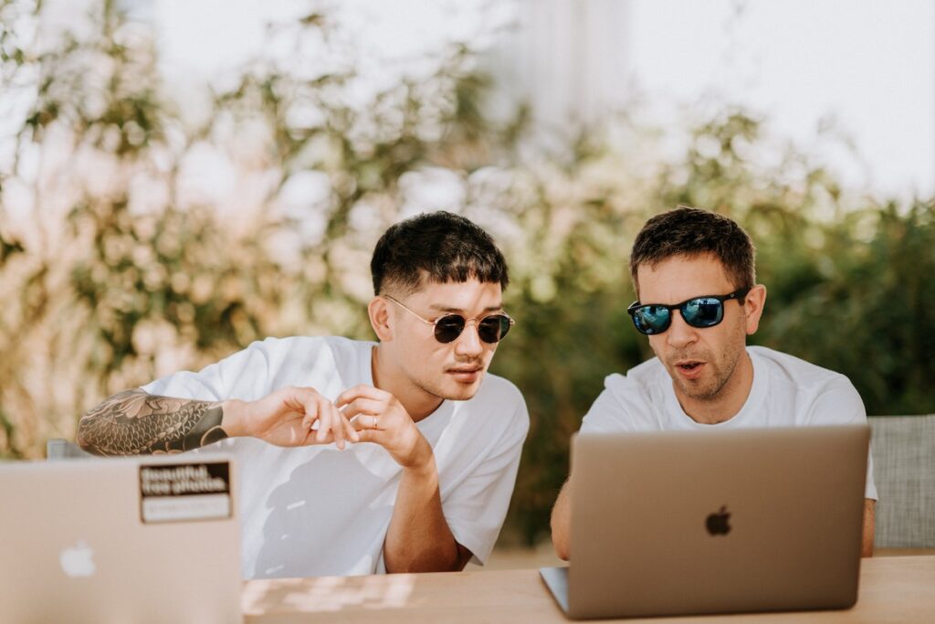 Two young men working together at a laptop