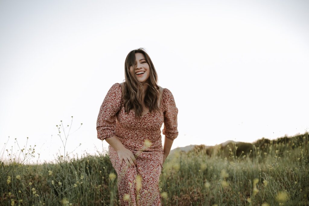 Image of a young woman smiling and running in a field