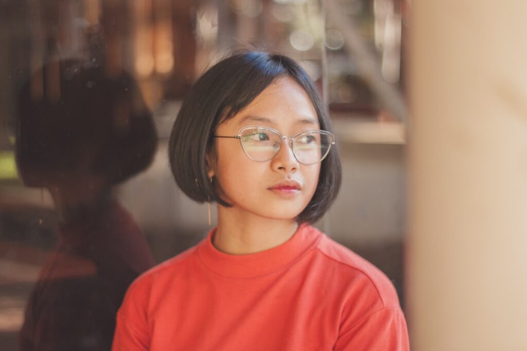 Portrait of a young woman in glasses and a red jumper