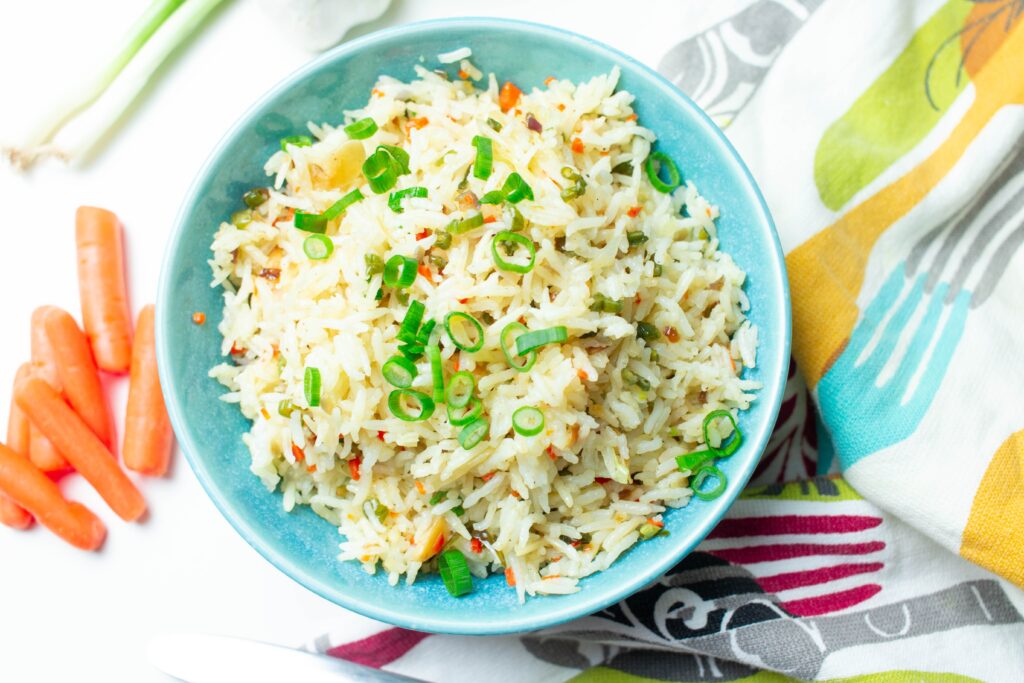 A blue bowl filled with rice and spring onion