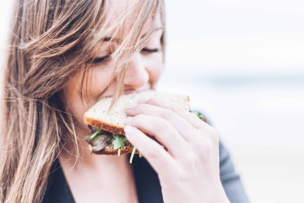 A woman eats a healthy sandwich