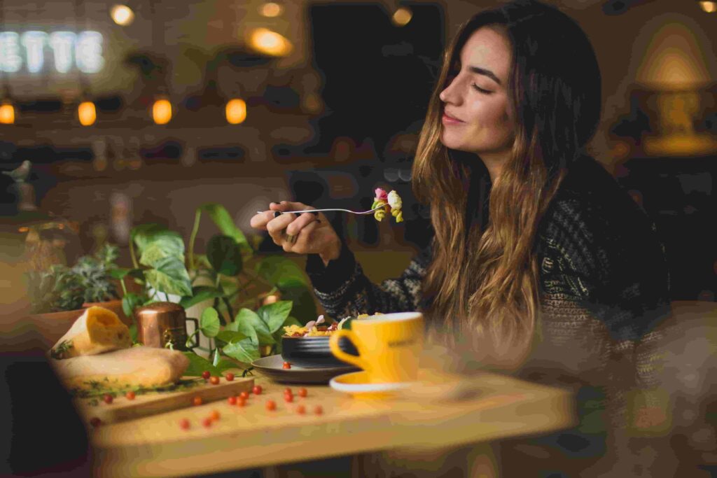 A woman eats food with a smile on her face