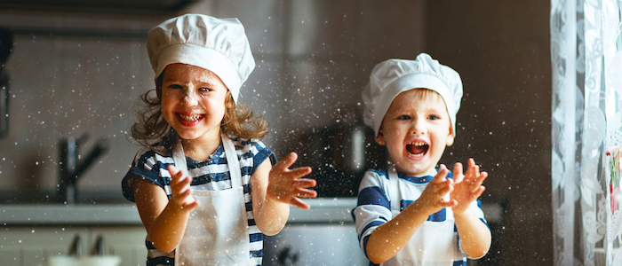 Young girl and boy preparing food and laughing