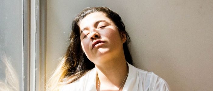 Woman with closed eyes in the sunshine