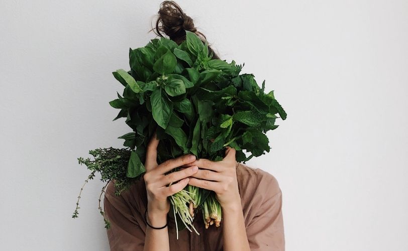 Woman holding veg in front of face