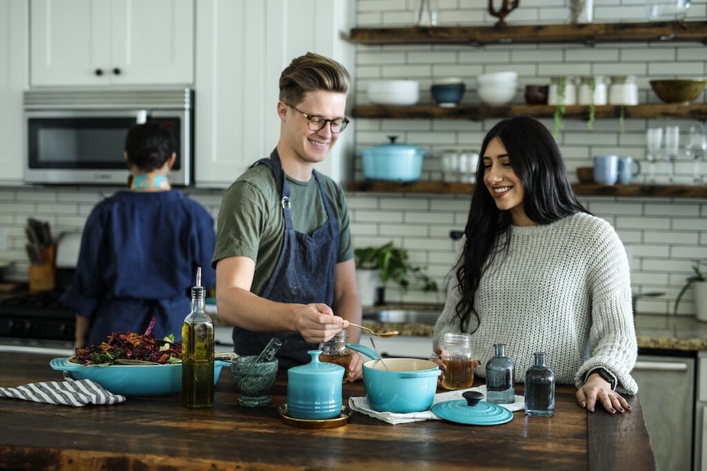 Two friends cooking together in a kitchen