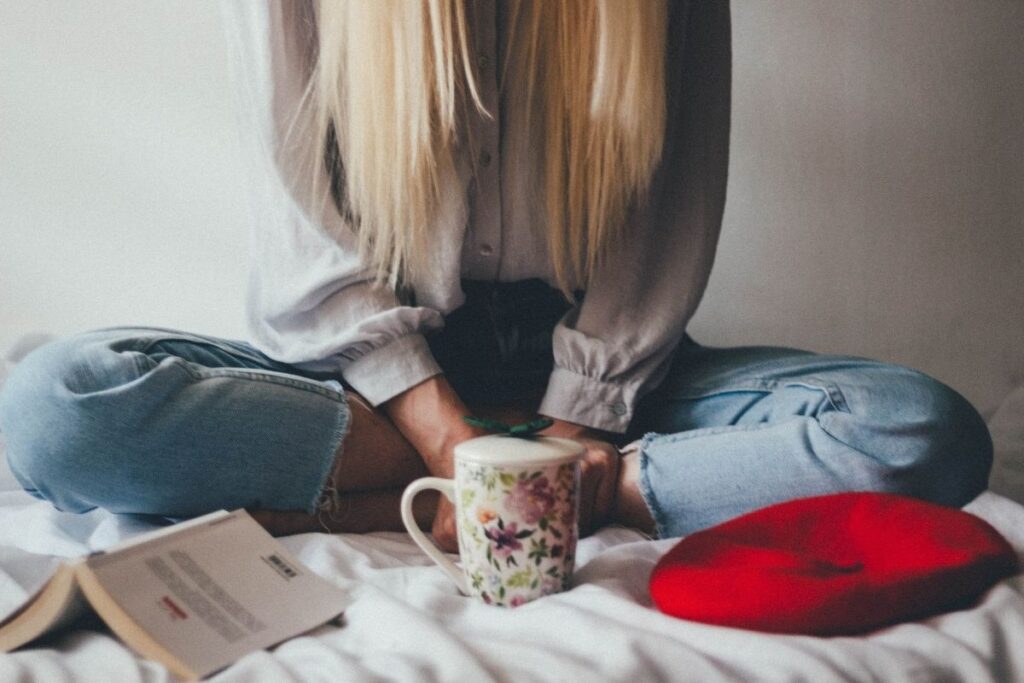 Girl sitting on bed with tea