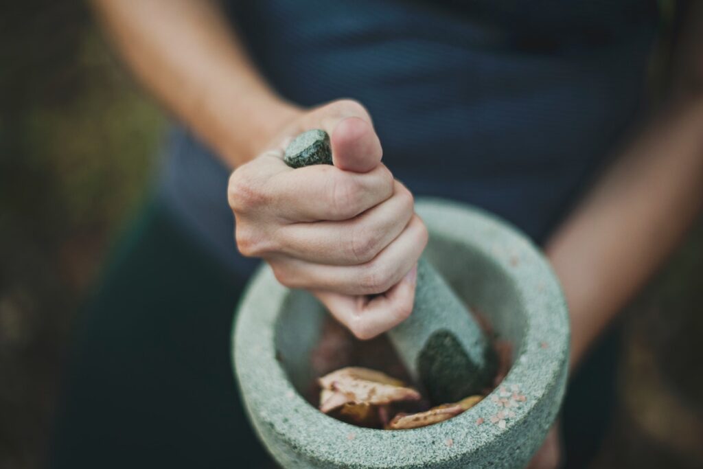 Woman preparing meal with pestle and mortar