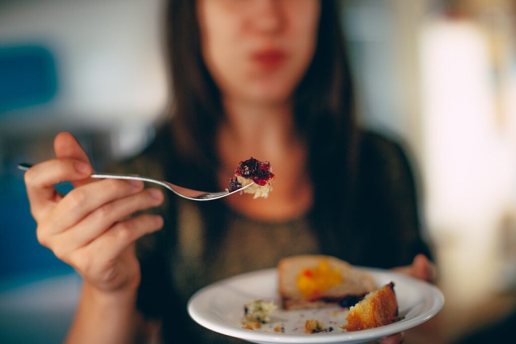 Woman holding spoon with cake on