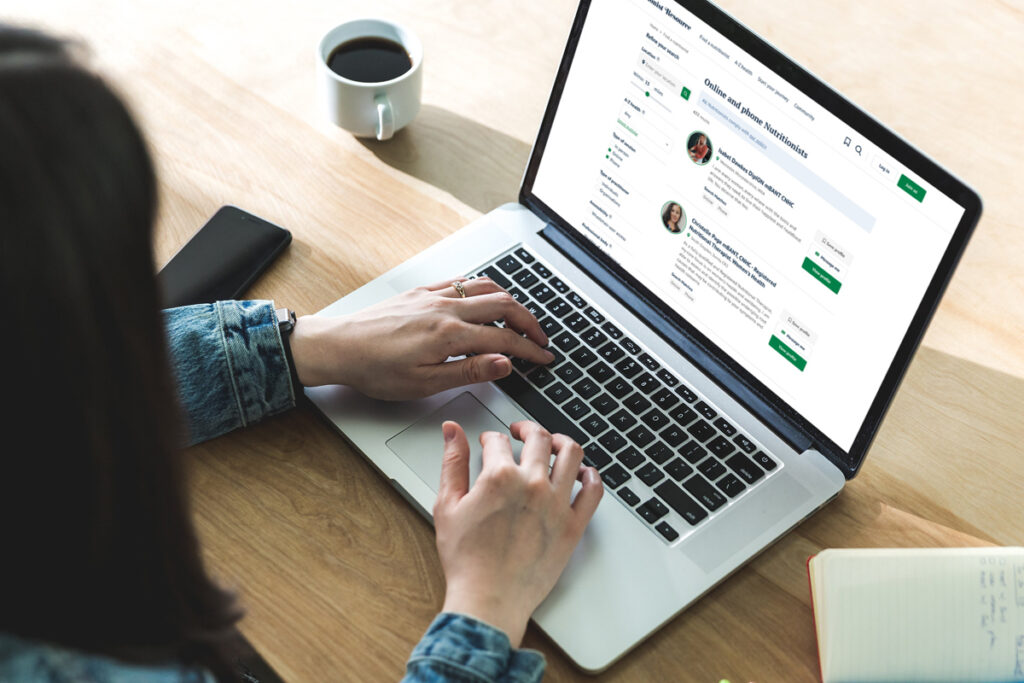 Woman using laptop to search on Nutritionist Resource