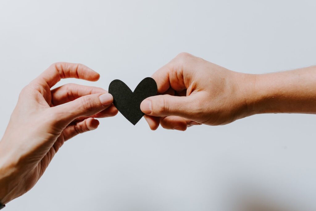 Two hands holding paper heart