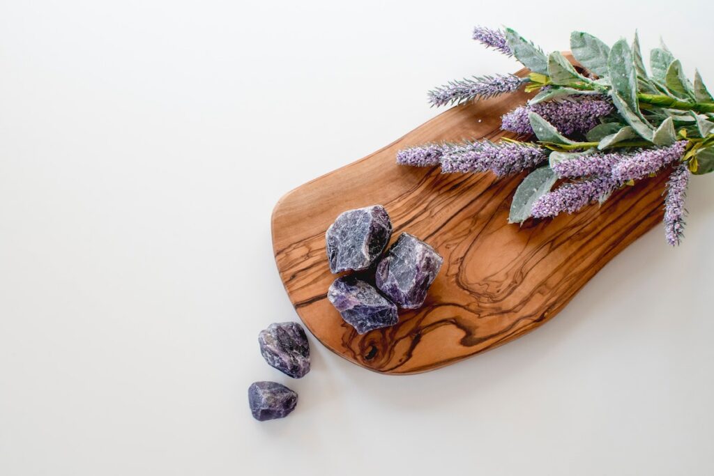 A chopping board with lavender and crystals