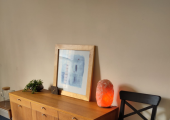The console sideboard with salt lamp, painting and clock on top.
