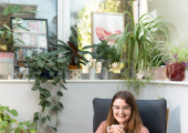 Picture of counsellor Lena Zagel smiling and holding coffee cup while sitting on a cushioned chair.