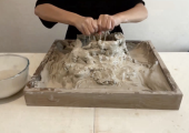 A client adding water to the clay during a Clay Field Therapy&reg; session.