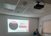 A meeting room with table & chairs. Presentation for the group 'Grounded' projected on the wall.