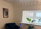 This a photo of a royal blue arm chair, in front of a glass modern table with water on it. This is inside my therapy room in Bank