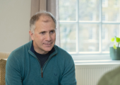 This is an image of a man who is a therapist, listening intently to a client sitting opposite