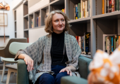 An image of a coach conducting a coaching session with a client in a calm room with bookshelves.