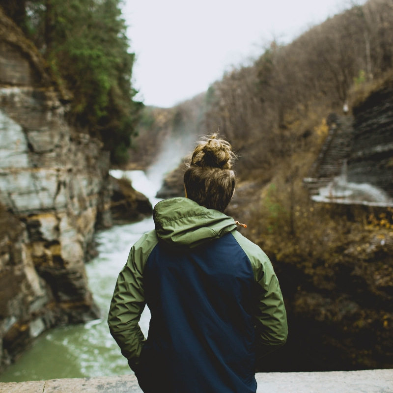 A young man looks across a river