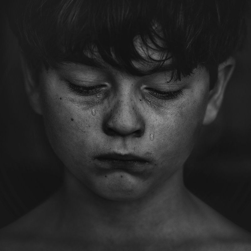 A young boy cries alone