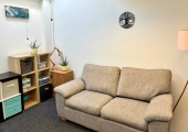 Comfortable sofa, warm lamp and plants in a welcoming Chichester counselling room.