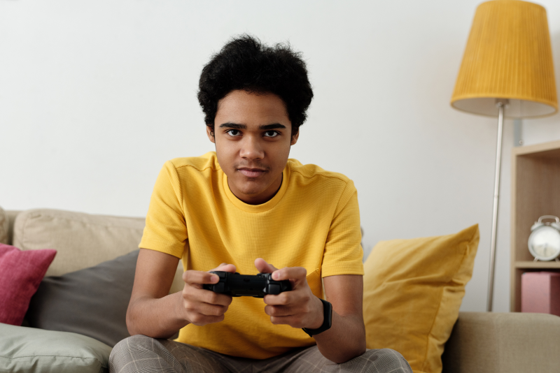Man in yellow t-shirt playing video games