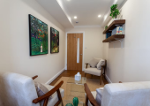 A cosy therapy room with various supportive armchairs and soft lighting.