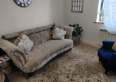 Coalville Counselling room. The room has a window with a curtain, an arm chair and a sofa.