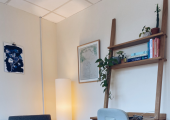 A chair in a room with a warm lamp.