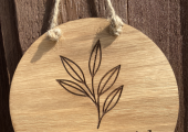 wooden circle with a plant carved into it and 'Emma Dowrick Counselling'