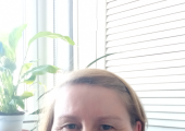 Me in my office sitting near the window with a plant on the window sill.