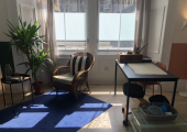 Desk and comfy chair area in front of the double window