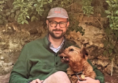 Jason sat on a bench with Luna, an Irish Terrier.