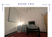 A larger room with books, games, dollshouse, sand trays, and whiteboard for therapy work
