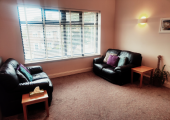 An image of two sofas in a soft lit room with a large window