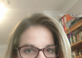 Woman wearing glasses in a soft lit room