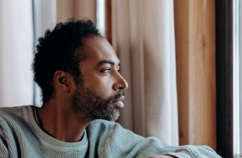 man looking out window