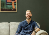 Nick, the owner of Neurodiversity Coaching, sitting on his sofa at home.