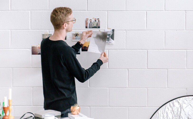 Young man hanging pictures on a wall
