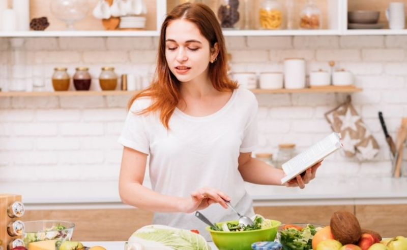 Woman in kitchen with recipe book