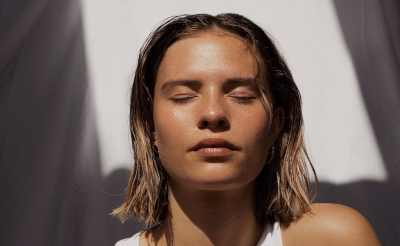 Woman facing sun with eyes closed