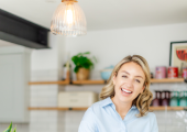 Picture of nutritionist smiling with a smoothie and laptop.