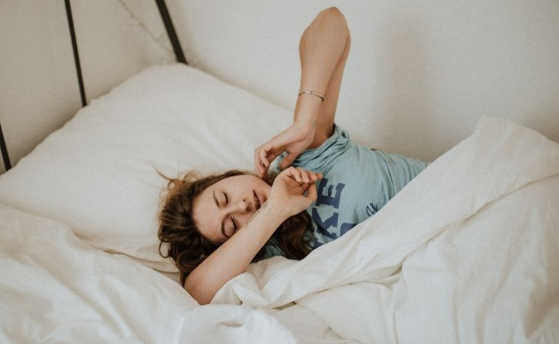 Woman in bed stretching